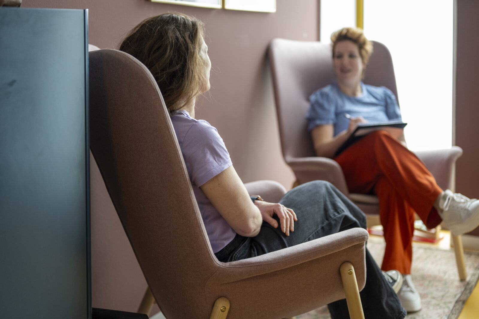 Therapist and client in a warm, comfortable therapy session