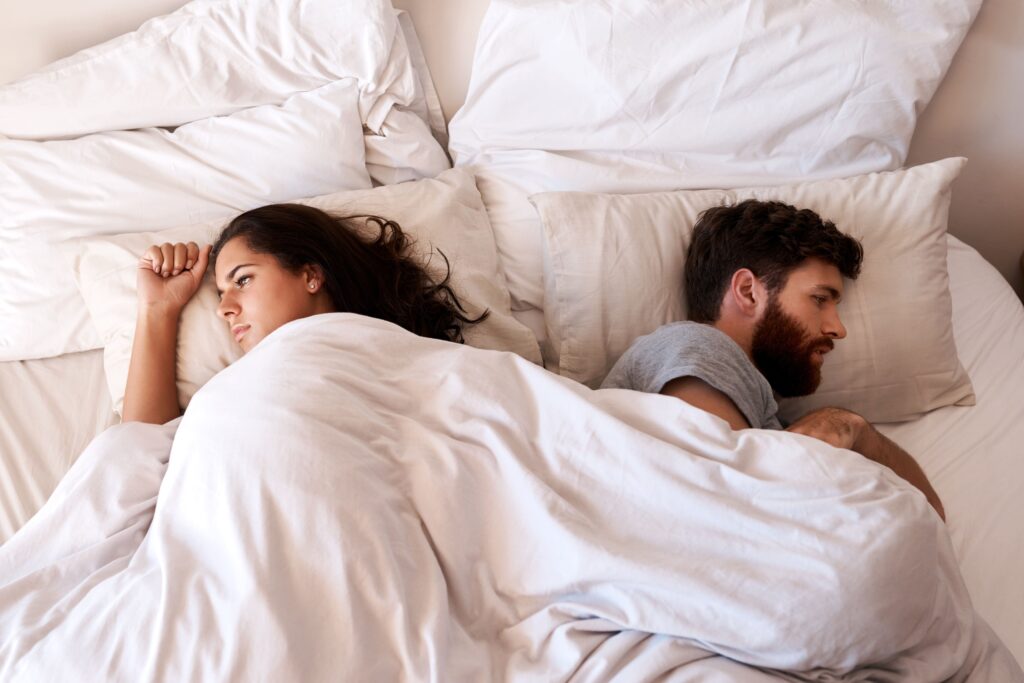 Person experiencing sexual performance anxiety and emotional distance during intimacy